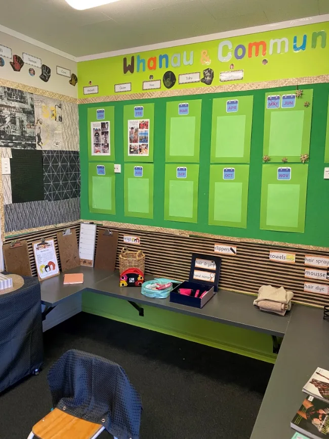 A whānau and community display wall filled with family photos and stories